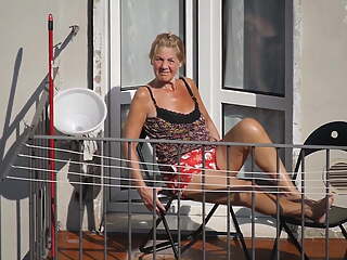 Candid granny while getting a tan on the balcony