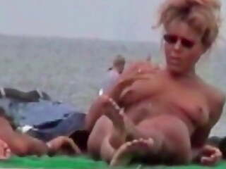 Dutch pussy spreads her legs on a nudist beach