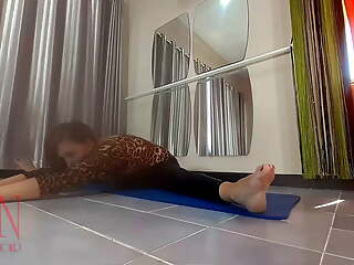 Regina Noir. A woman in a leopard bodysuit and latex leggings is doing yoga in the gym. Yoga in sexy leotards. 