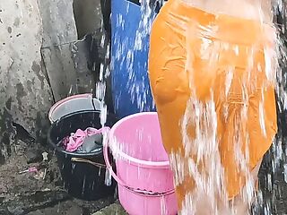 Indian house wife bathing outside 