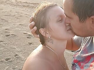 Hot couple on the Nudian beach enjoying handjob in the sea air.