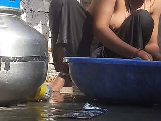 Indian stepsister is preparing to take a bath while washing clothes in the open courtyard of the house