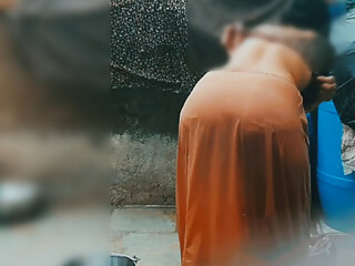 The desi sister-in-law of the village opened the drenched saree and took a bath in the open bathroom.